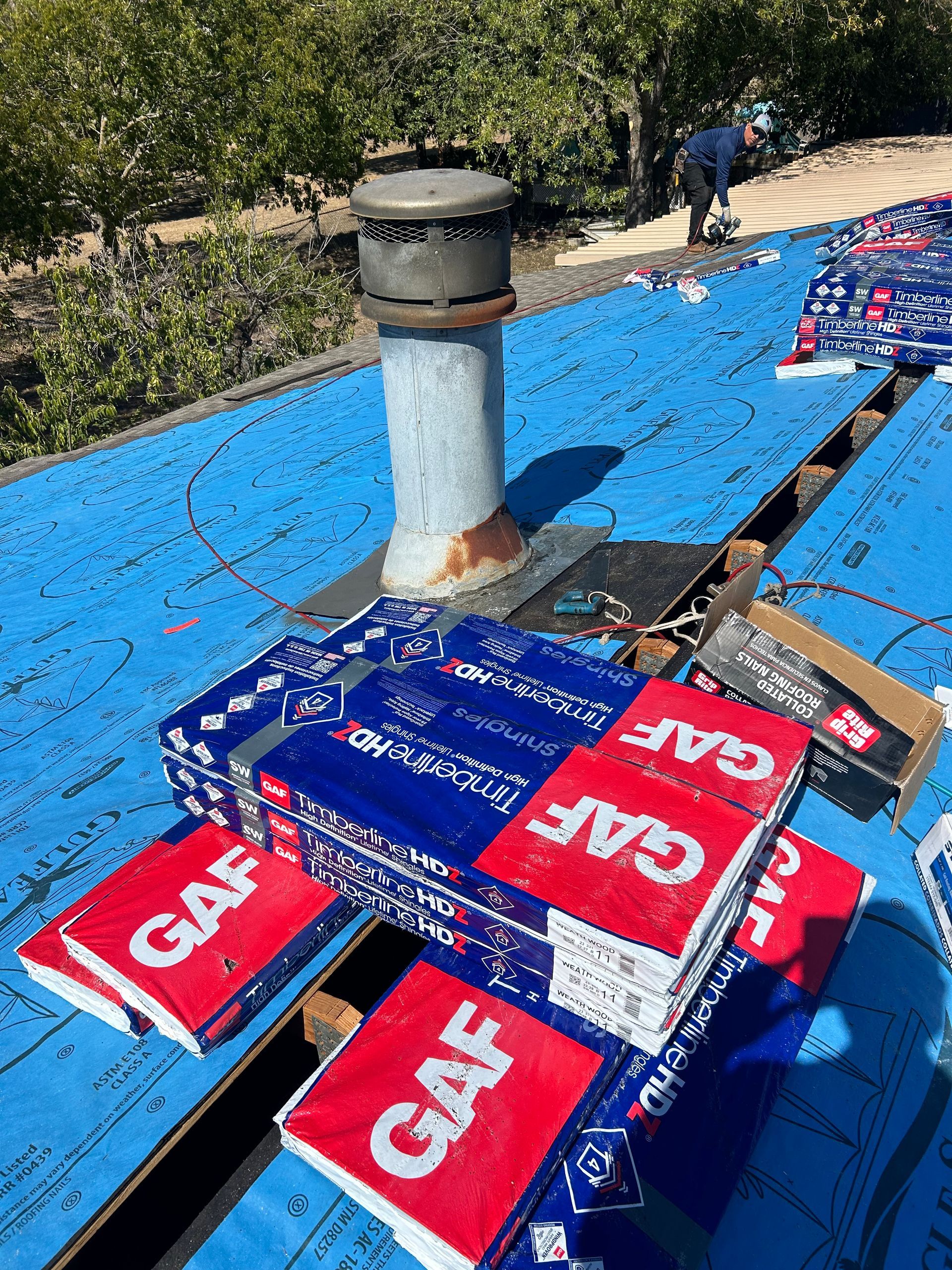 A roof with a chimney and a lot of boxes on it.