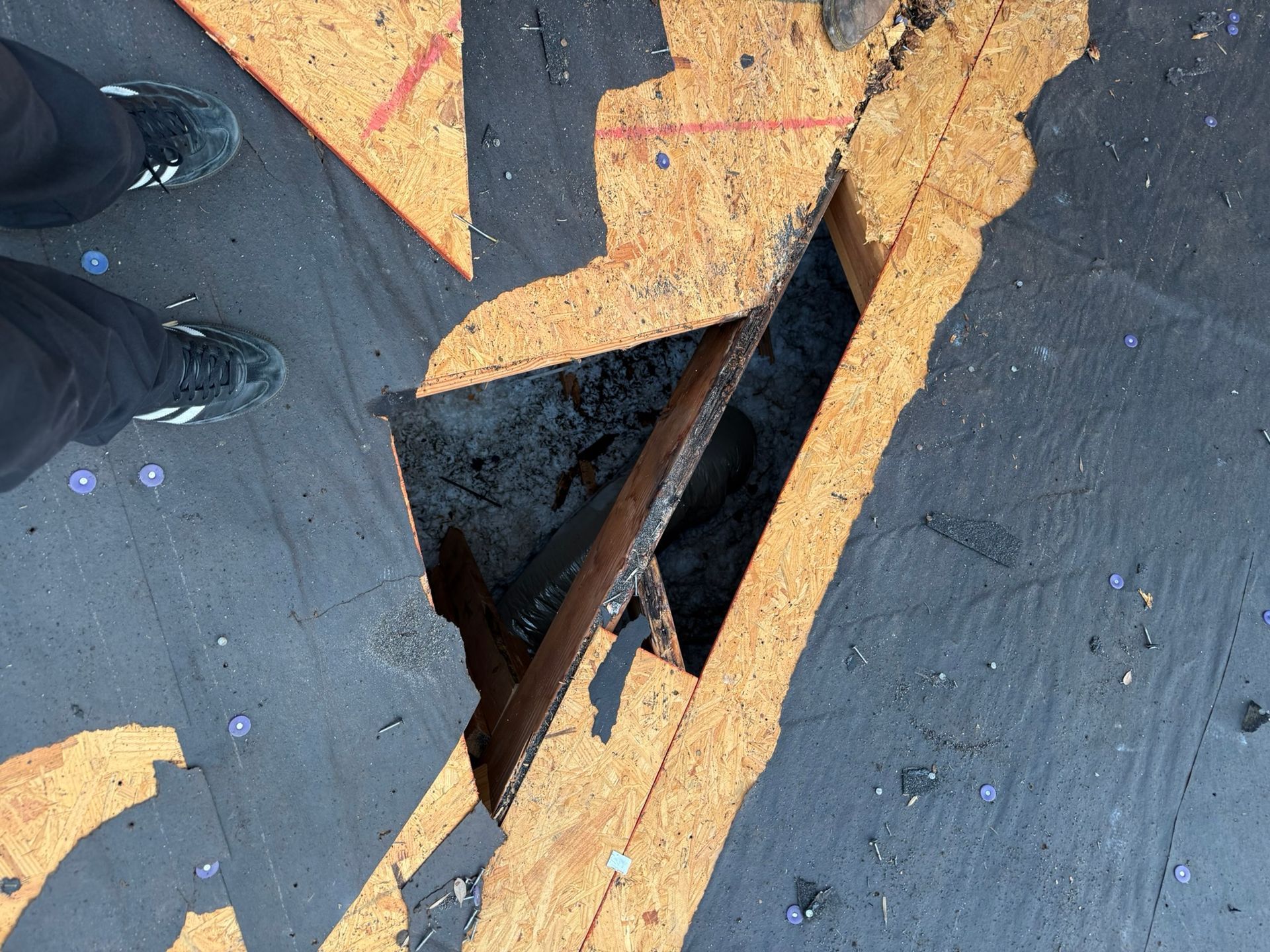 A person standing on a roof with a hole in it