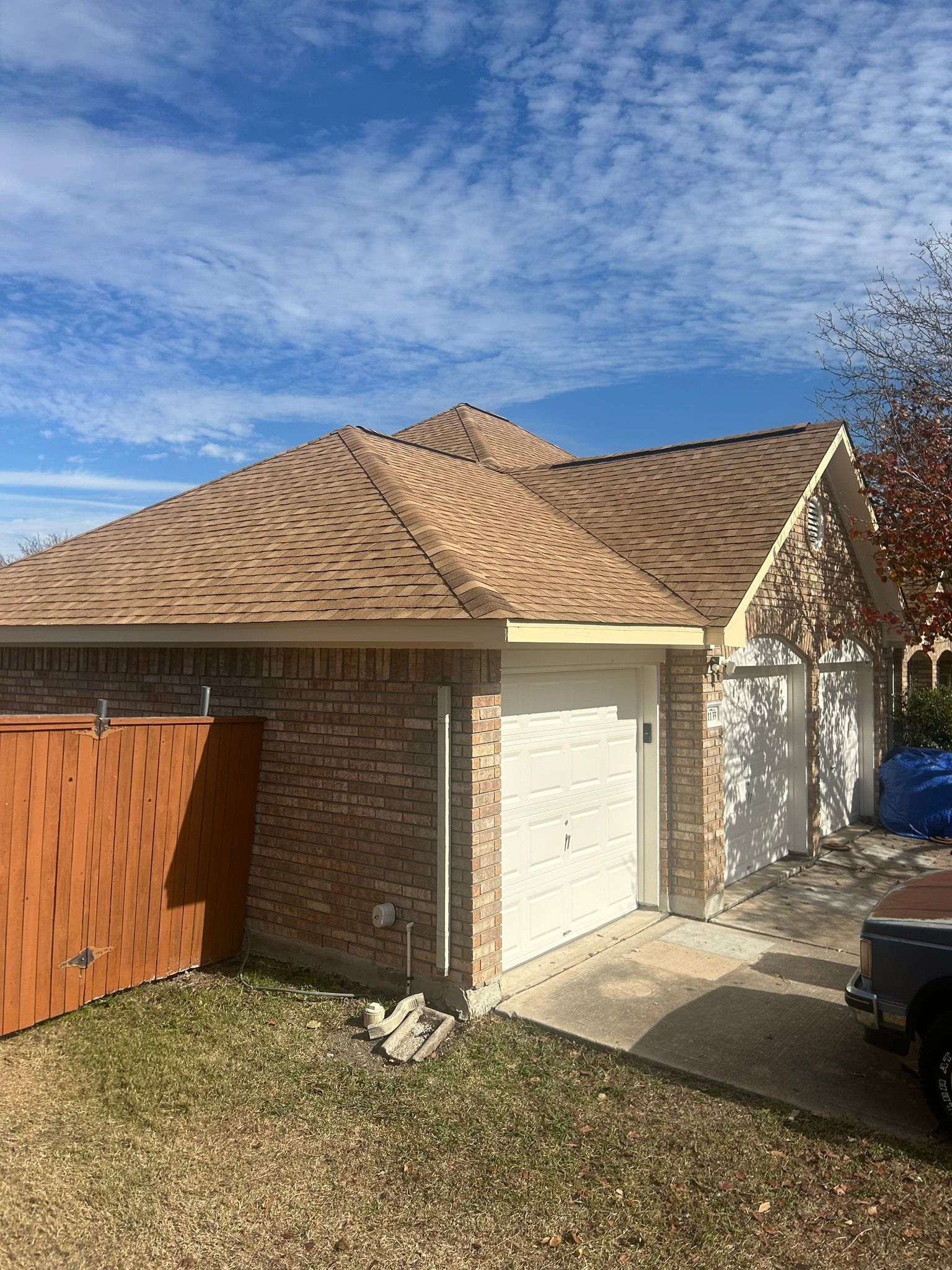 A house with a garage and a car parked in front of it.