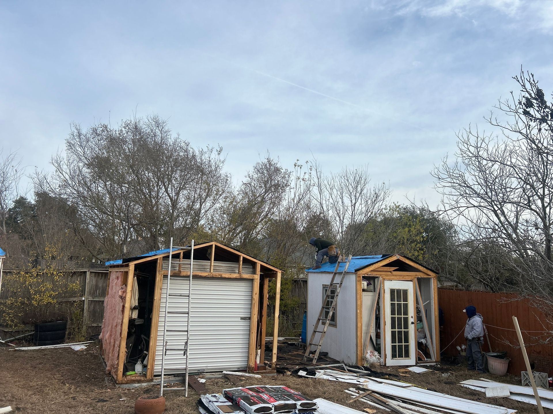 A couple of sheds are being built in a backyard.