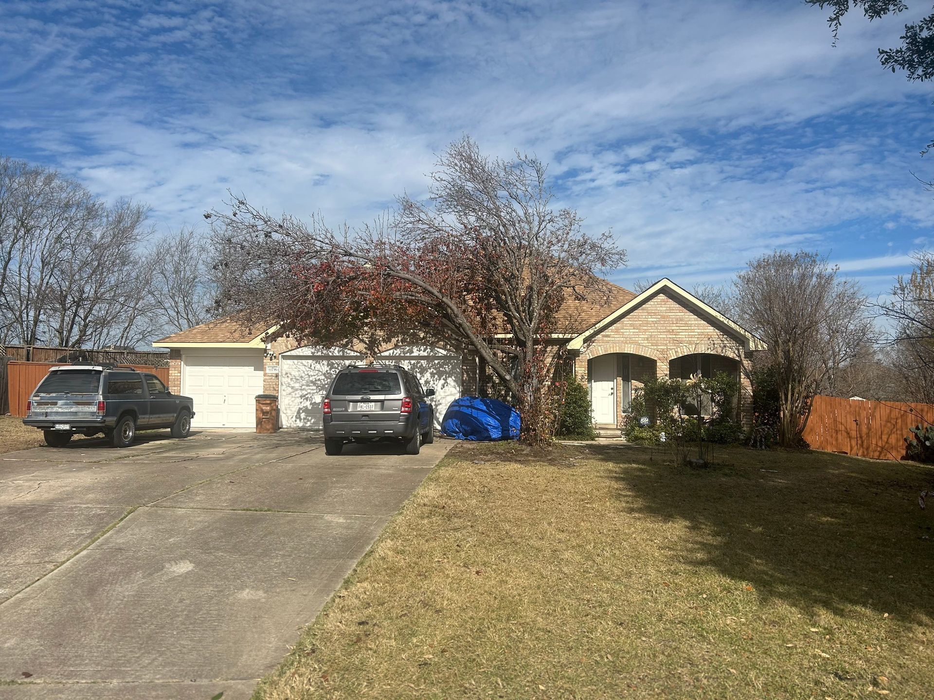 A couple of cars are parked in front of a house.