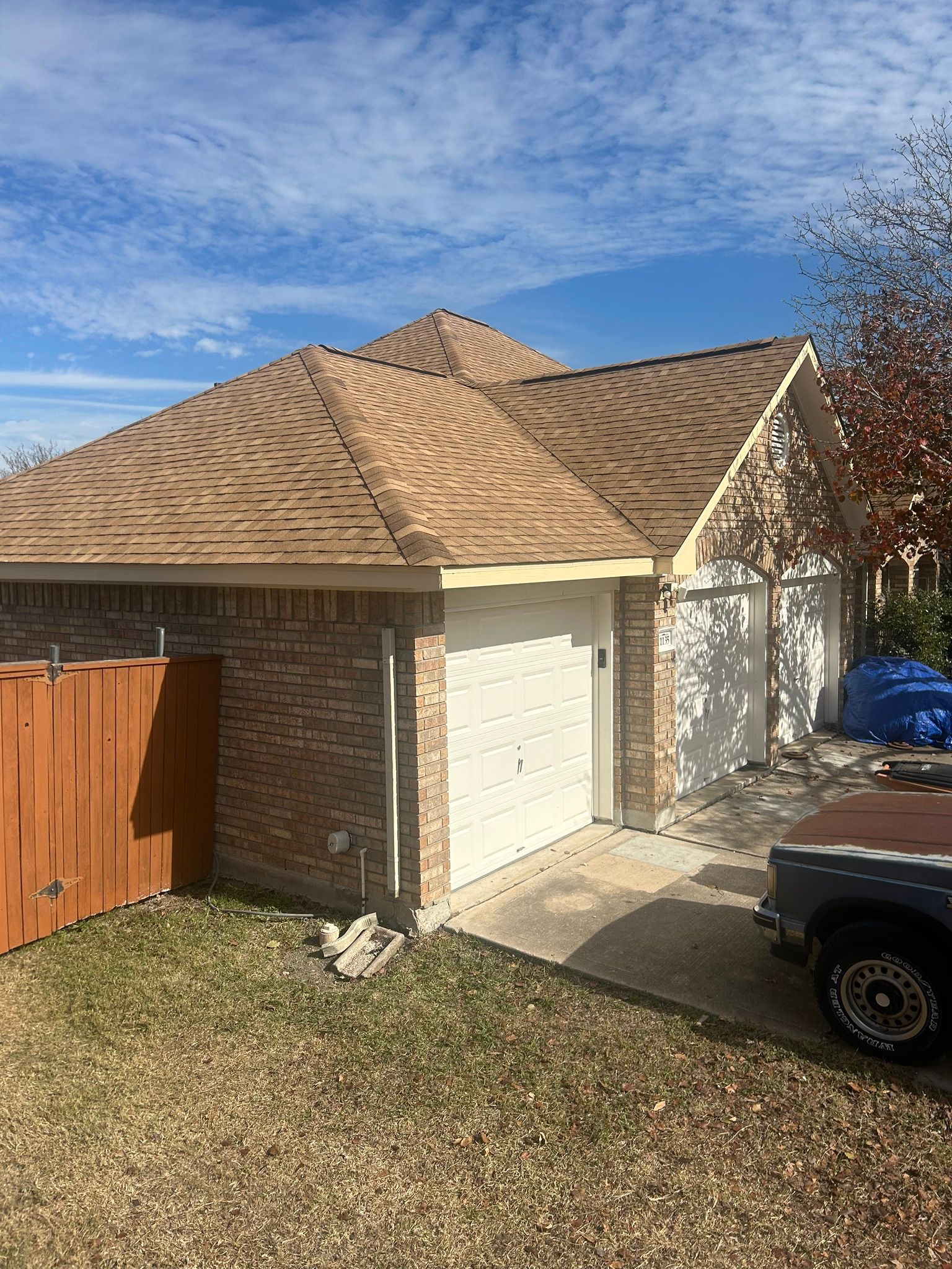 A house with a garage and a truck parked in front of it.