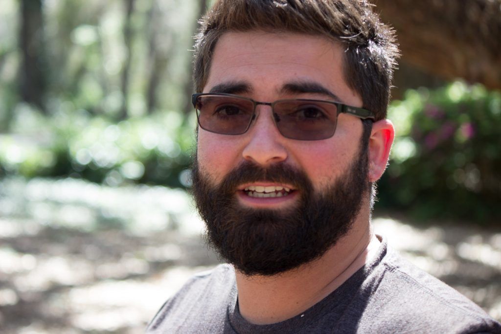 A man with a beard and sunglasses is smiling for the camera.