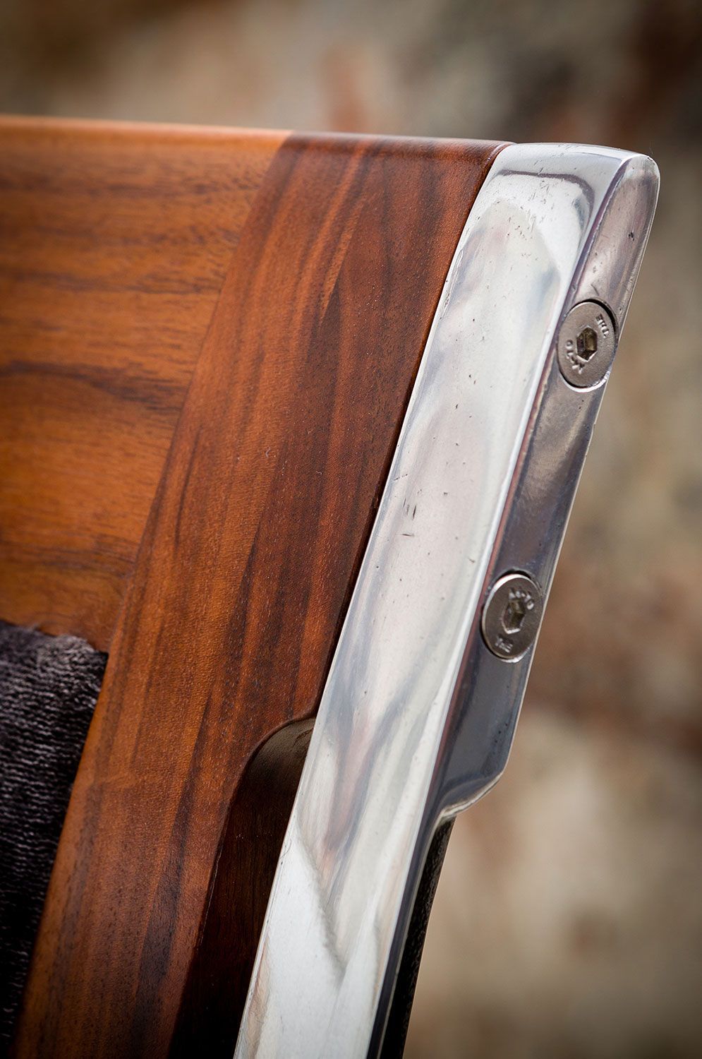A close up of a wooden chair with a metal frame. designer furniture worldwide