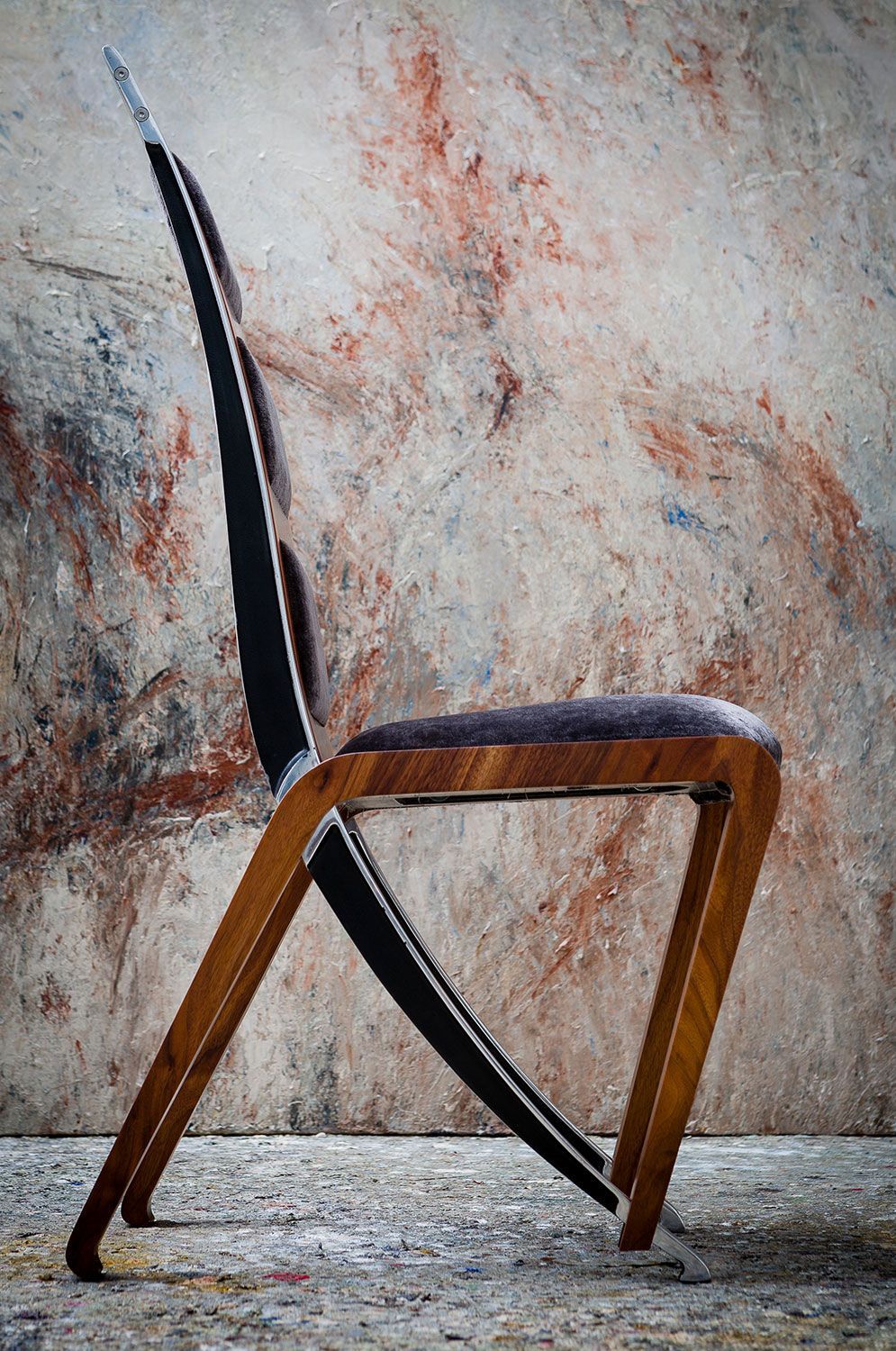 A high end designer wooden chair is sitting in front of a wall.