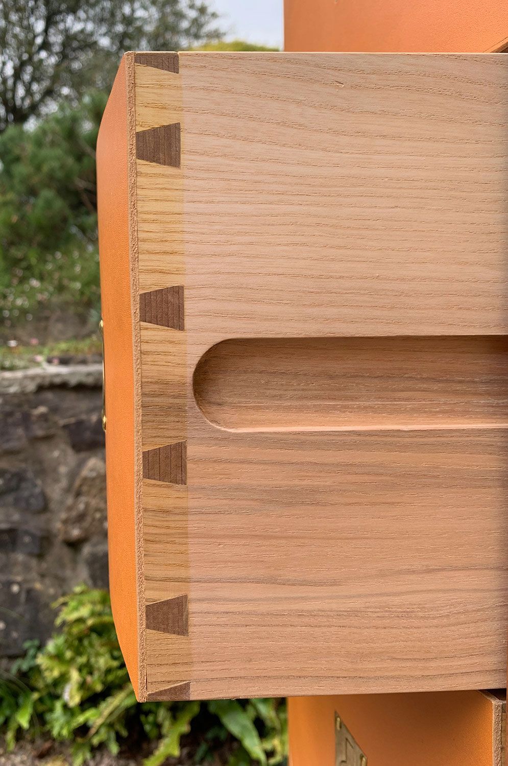 A close up of a piece of designer wood work with a hole in it.