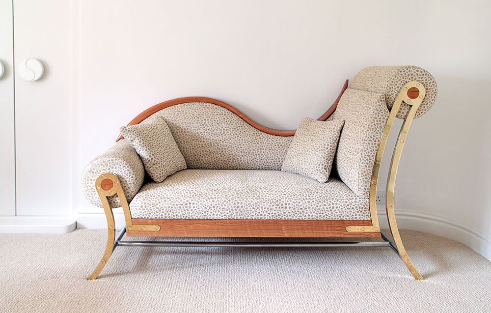 The chaise lounge is a contemporary designer sofa sitting on a carpeted floor in a room.