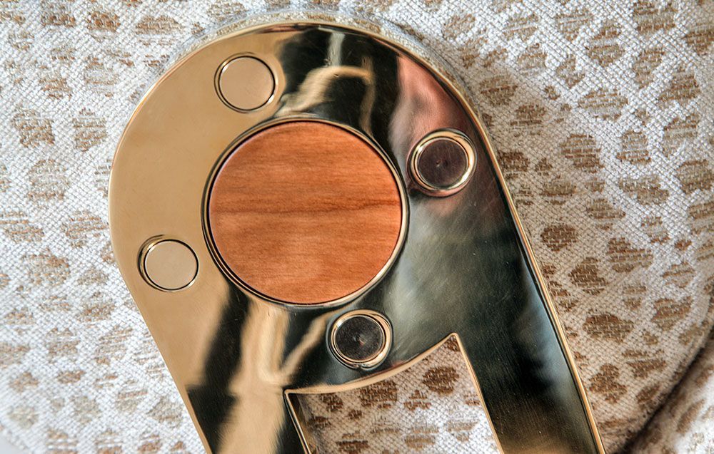 A handcrafted gold plate with a wooden circle on it