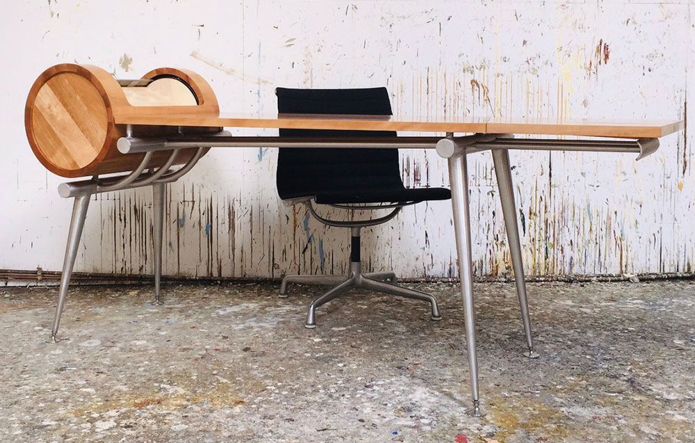 A  modern wooden table with a black designer chair underneath it