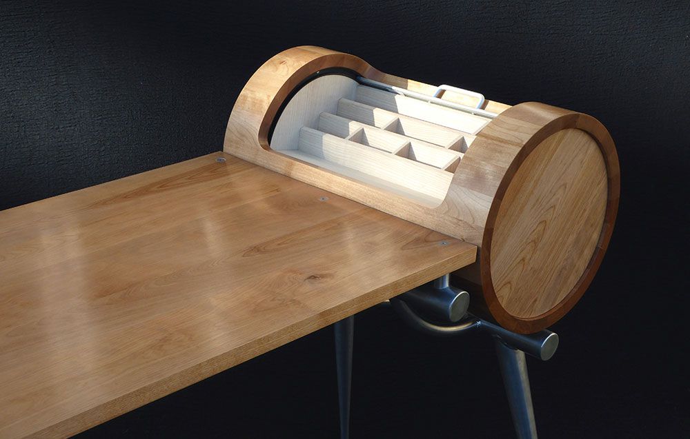 A handcrafted modern wooden table with a barrel shaped drawer underneath it