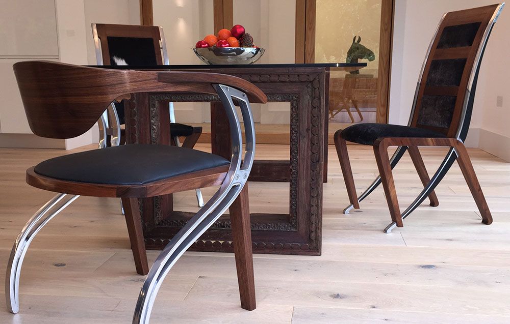 A custom built dining room table and  dining chairs with a bowl of fruit on it