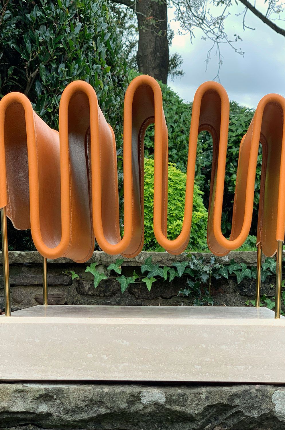 A custom magazine rack in the sculpture of a wave is sitting on top of concrete slabs