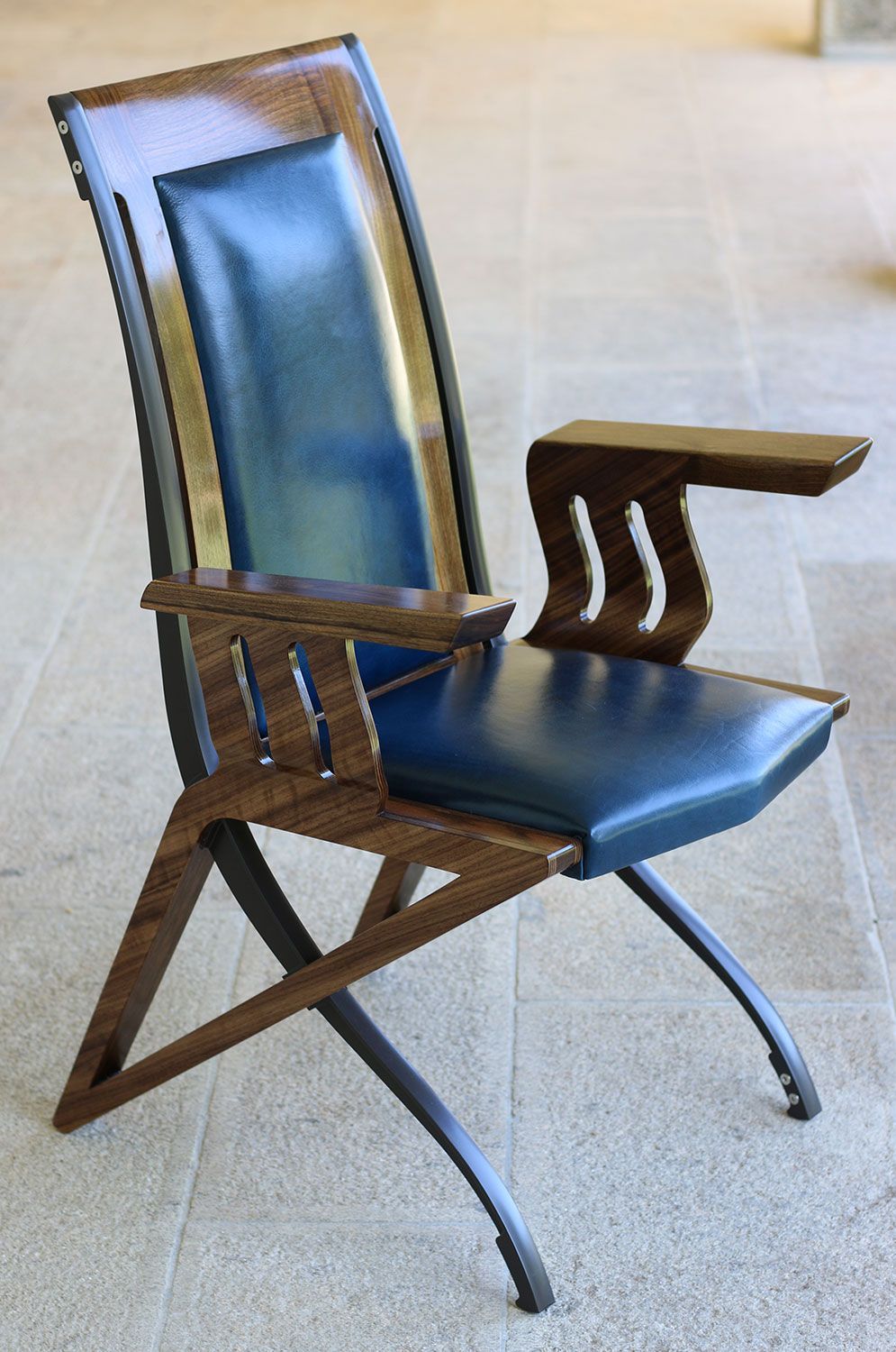 A high end wooden chair with a blue leather seat and back