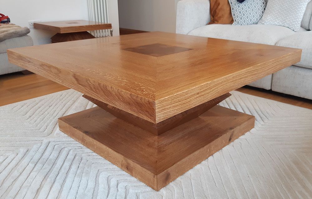A set of two unique handcrafted oak coffee table is sitting on top of a white rug in a living room.