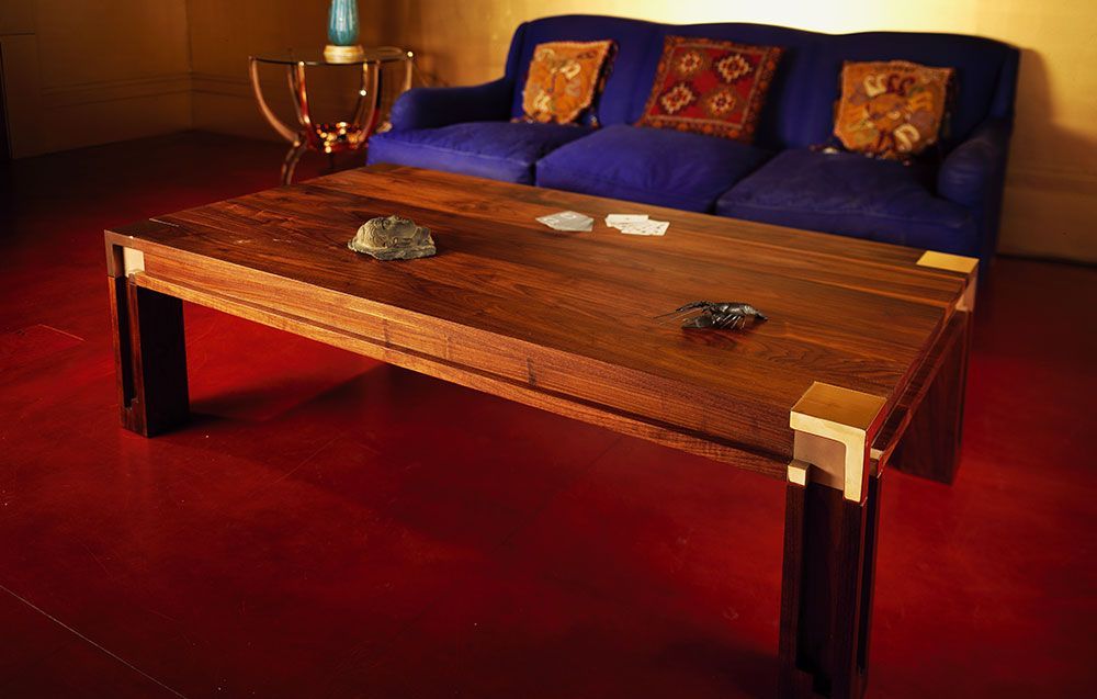 A living room with a blue couch and a wooden table