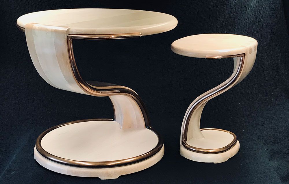 A small table and a large designer sycamore table are sitting next to each other