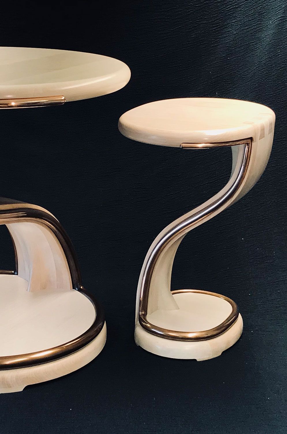 Two white custom sycamore tables with gold trim are sitting next to each other