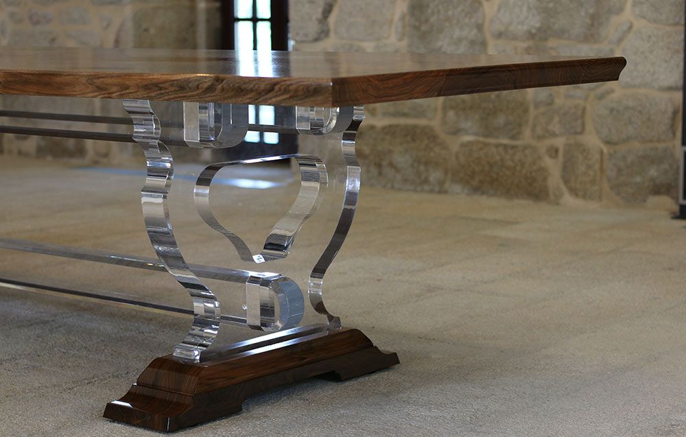 A tailor made wooden chair is sitting next to a handcrafted table in a room.