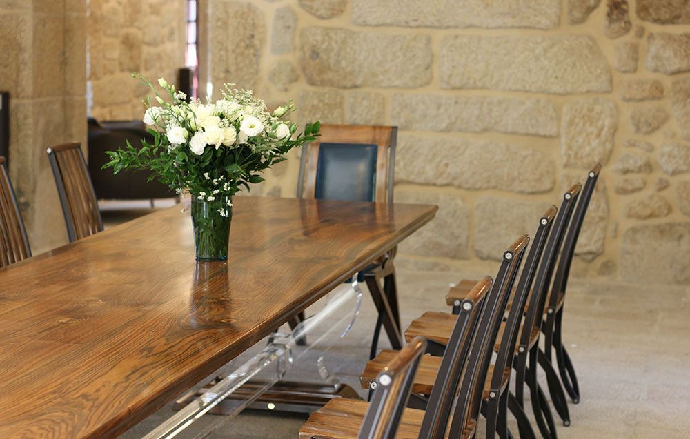 Flying Walnut Dining Table, a wooden table with a vase of flowers on it