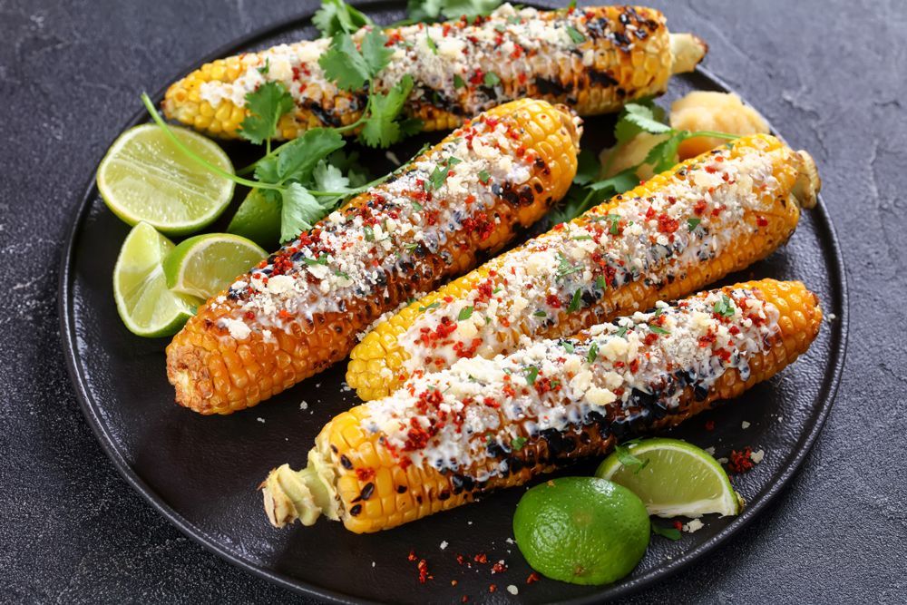 grilled corn on the cob with limes and El Viajero cheese