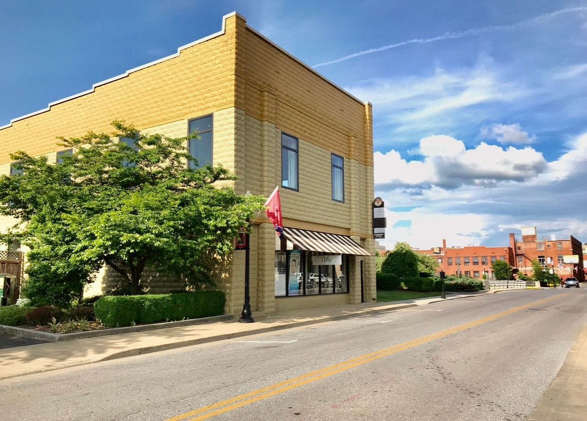 Building with awning and American flag; a Sugar Mama business sign visible.