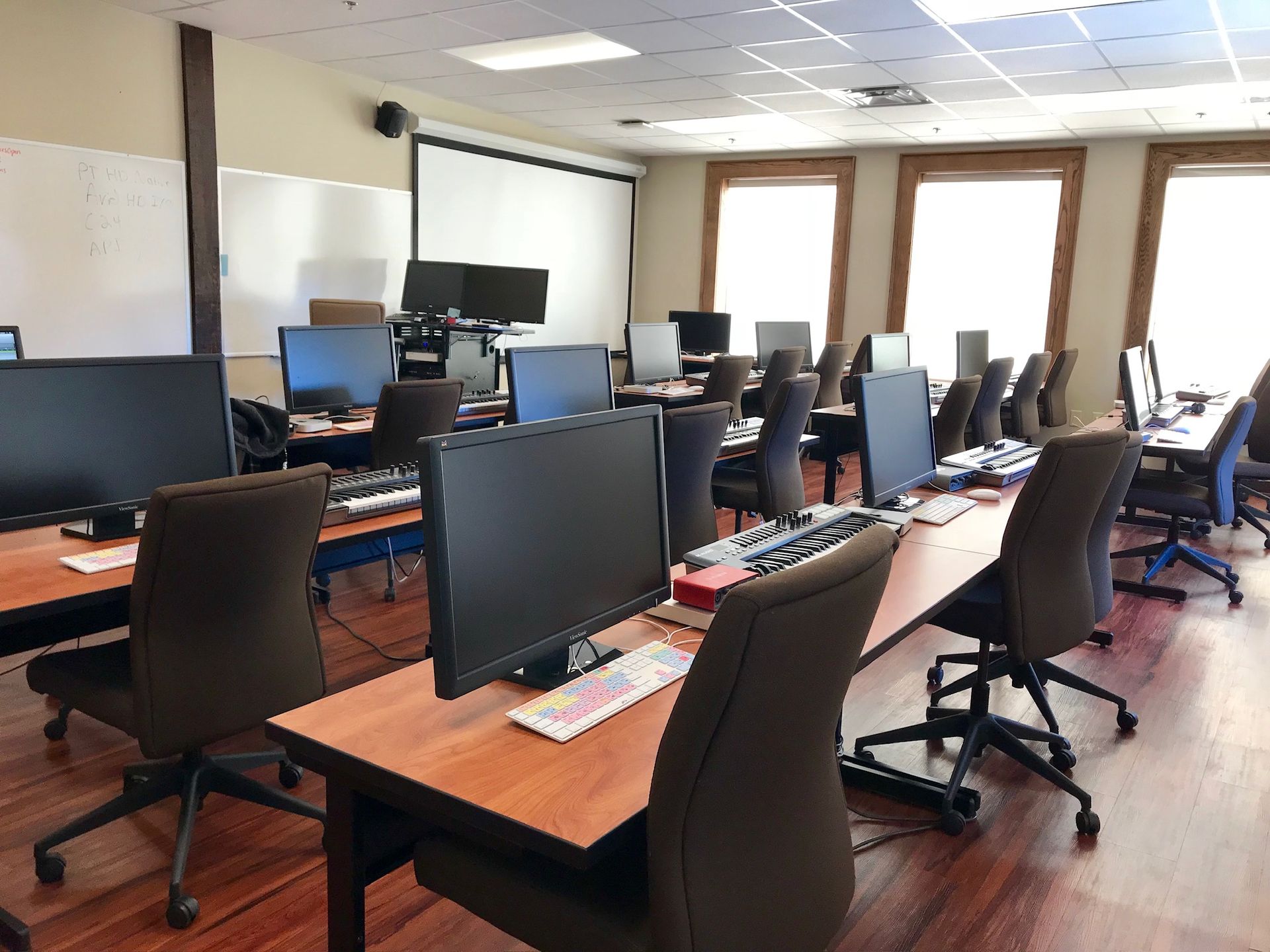 View Commercial Leasing Options Computer lab with desks, chairs, monitors, and a projector screen.