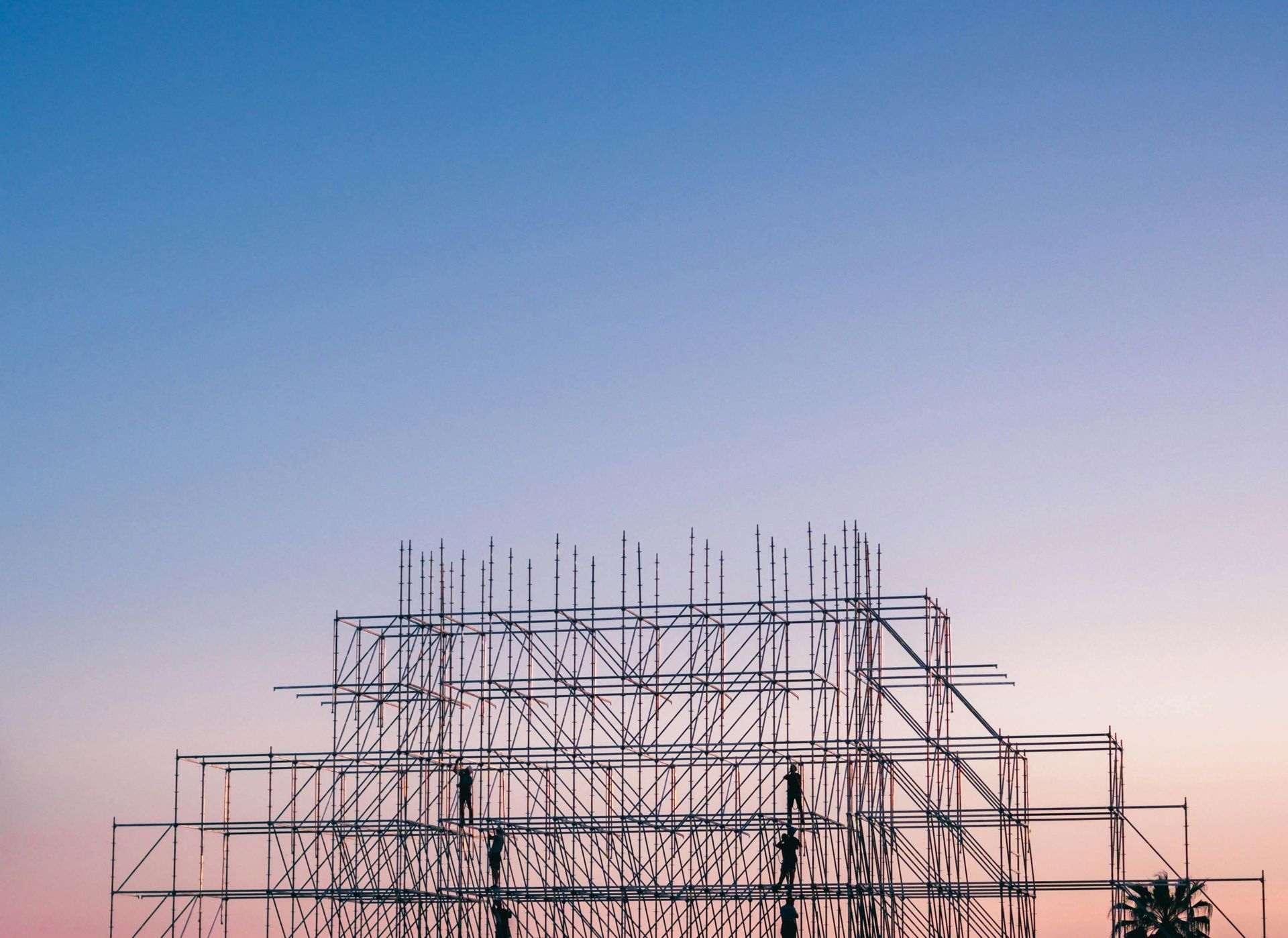 Scaffolding framework against a blue and pink gradient sky.