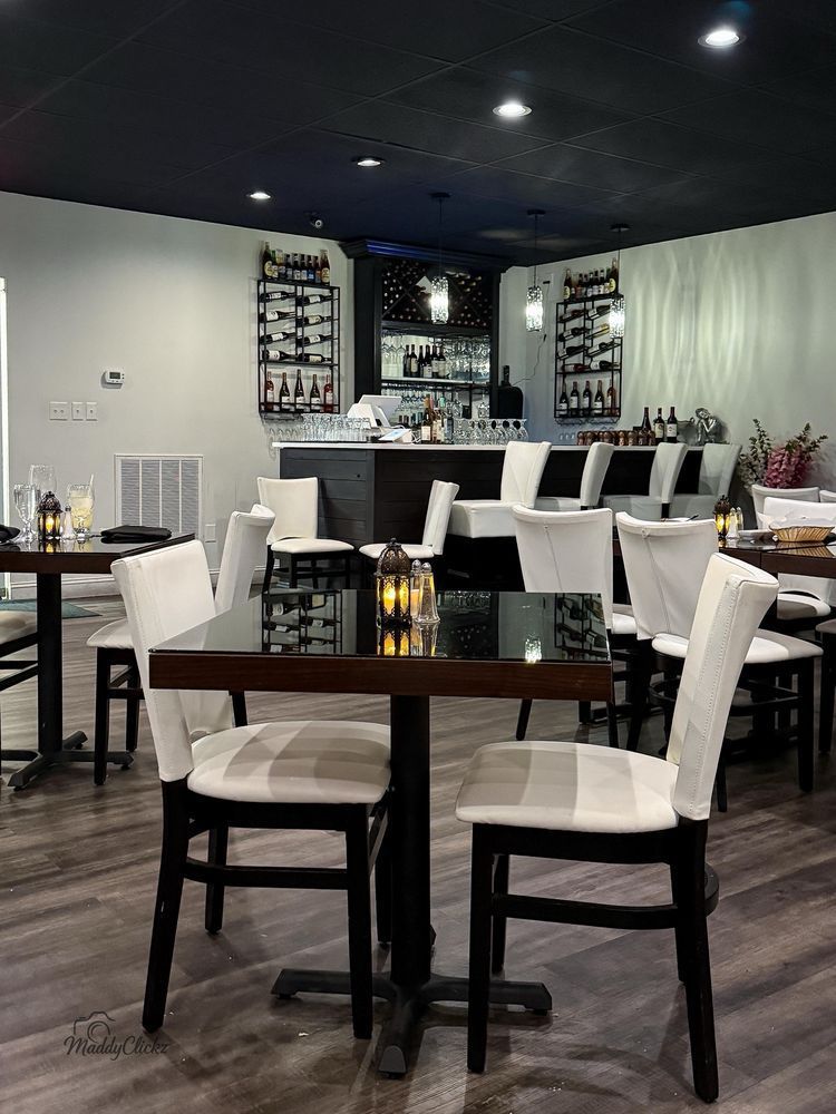 Two-story yellow brick building with US flag, awning over business front, and street lamp.