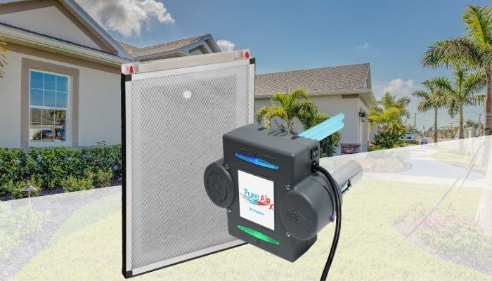 An air filtration system with a filter panel and a powered unit, set on grass in front of a house.