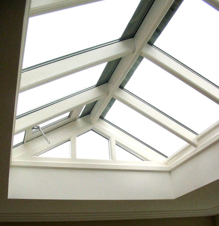 Skylight with white wooden beams and glass panels in a light-coloured room, providing natural light.