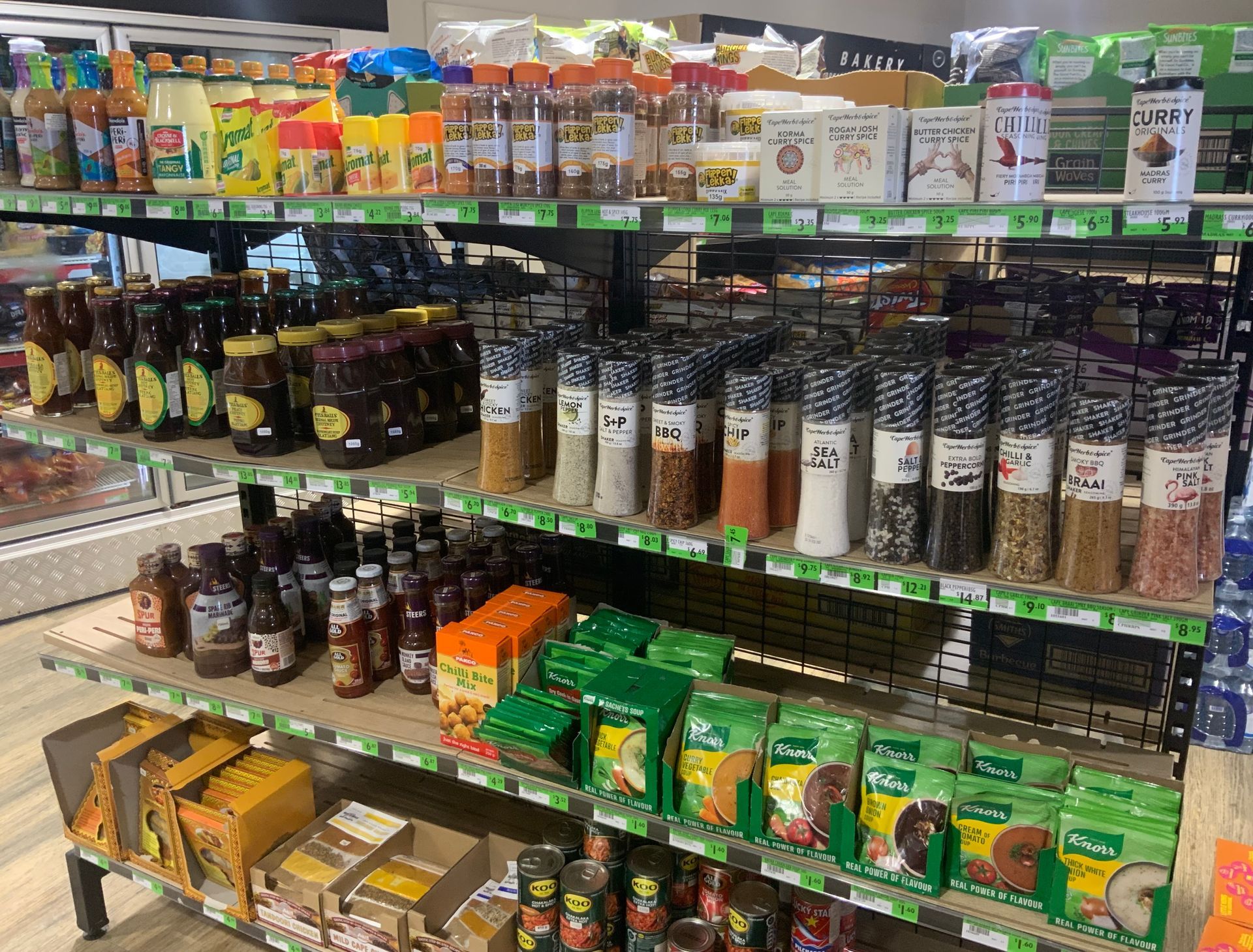 A supermarket aisle lined with shelves of colorful packaged foods and jars.— Cedar Park Supermarket In Taranganba, QLD