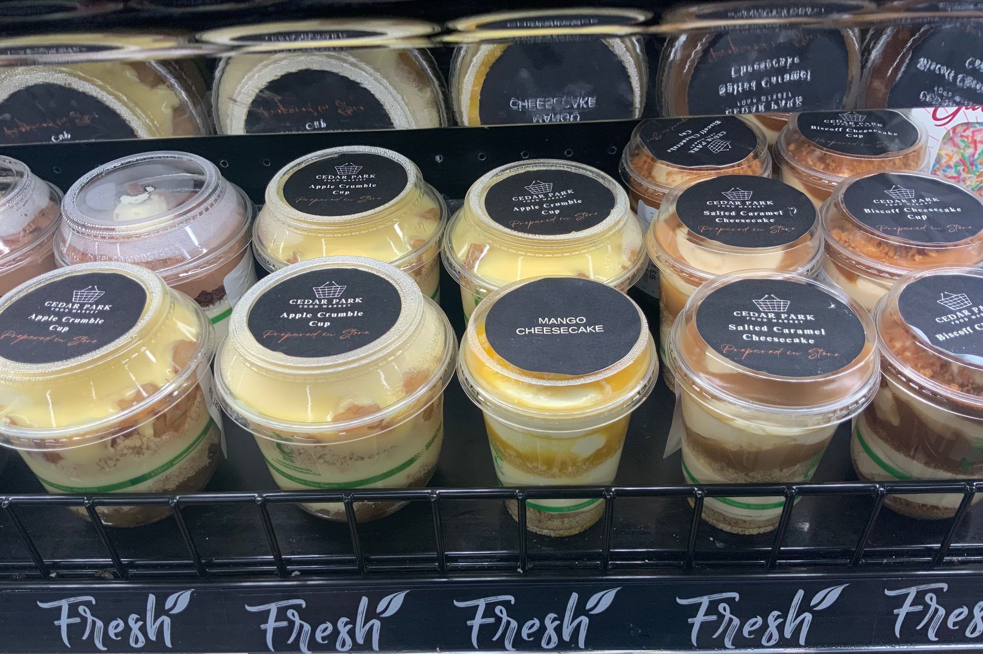 Assorted Dessert Cups in A Refrigerated Display, Topped with Dark Labels — Cedar Park Supermarket In Taranganba, QLD