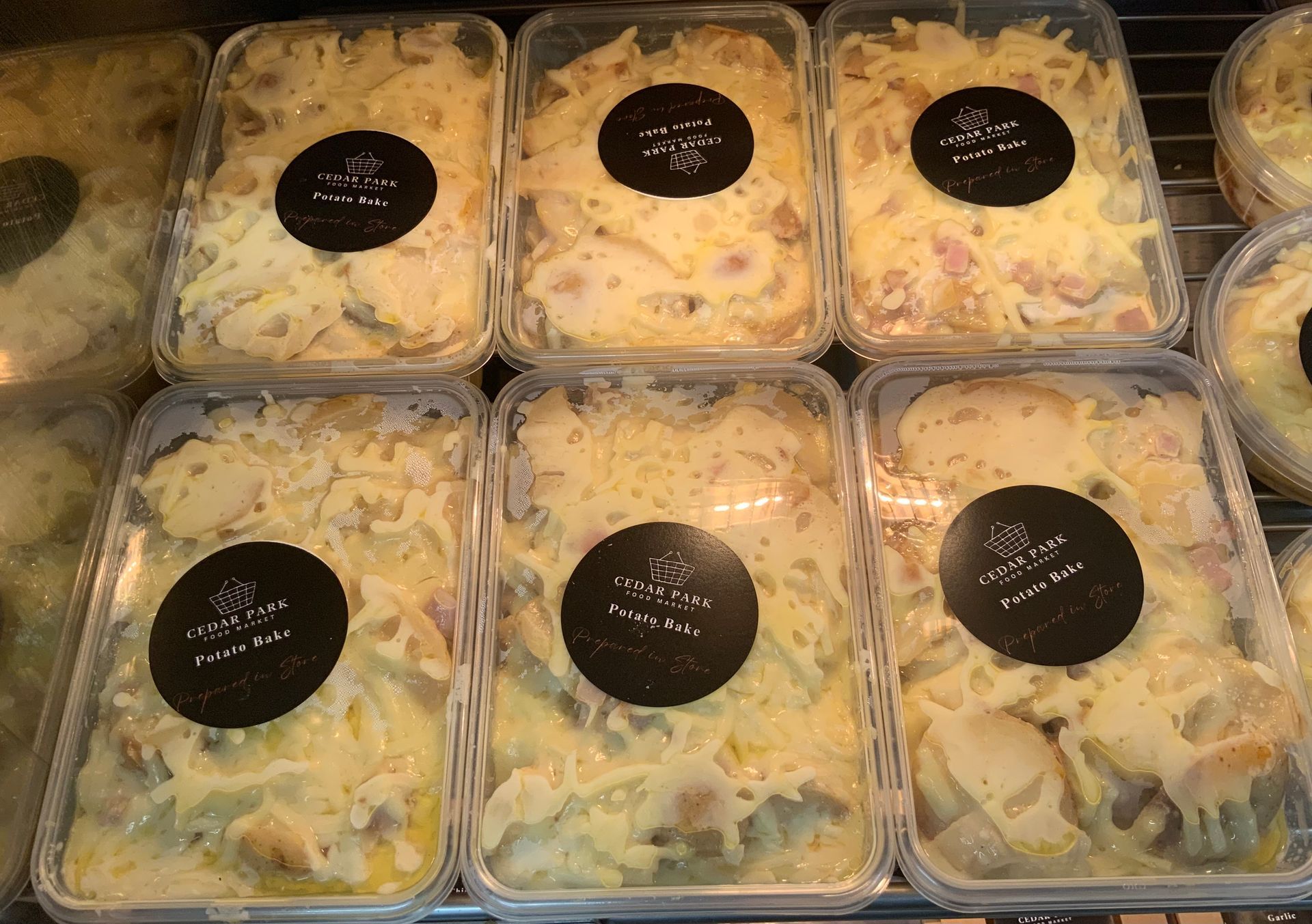 Trays of Prepared Salad Containers with Black Label Stickers — Cedar Park Supermarket In Taranganba, QLD