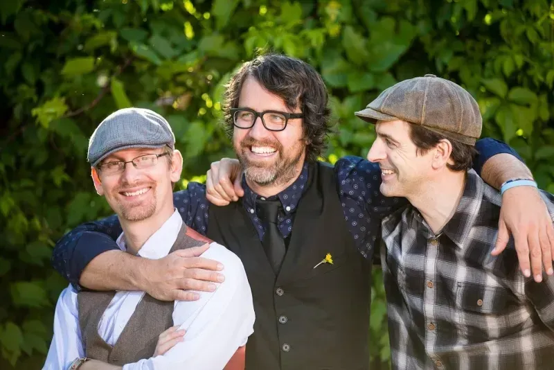 A group of three men are posing for a picture together.