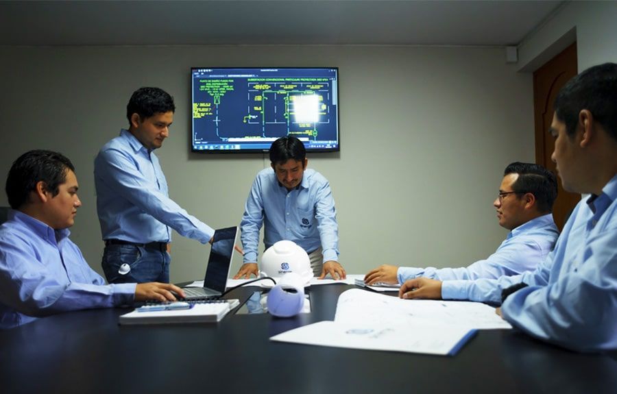 Un grupo de hombres está sentado alrededor de una mesa teniendo una reunión.