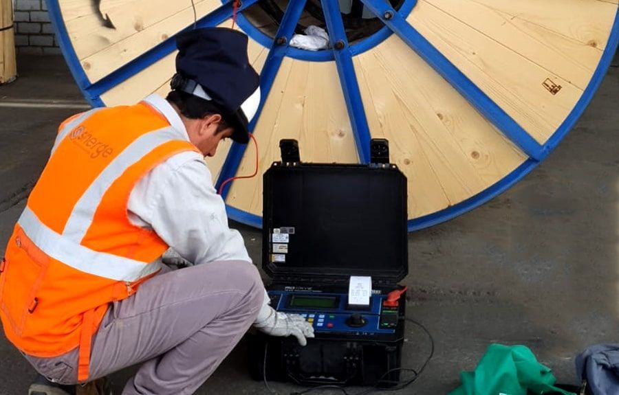 Un hombre con un chaleco naranja está trabajando en una máquina.