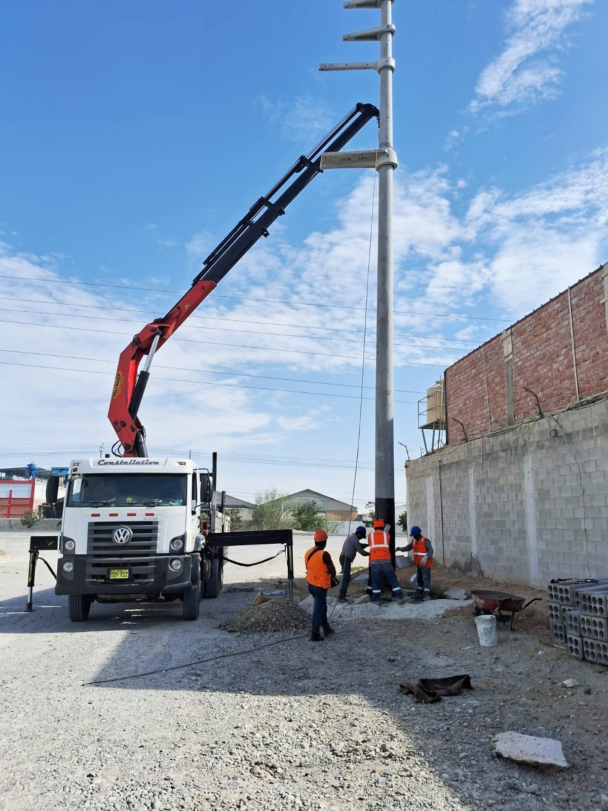 Se utiliza un camión con una grúa acoplada para levantar un poste.