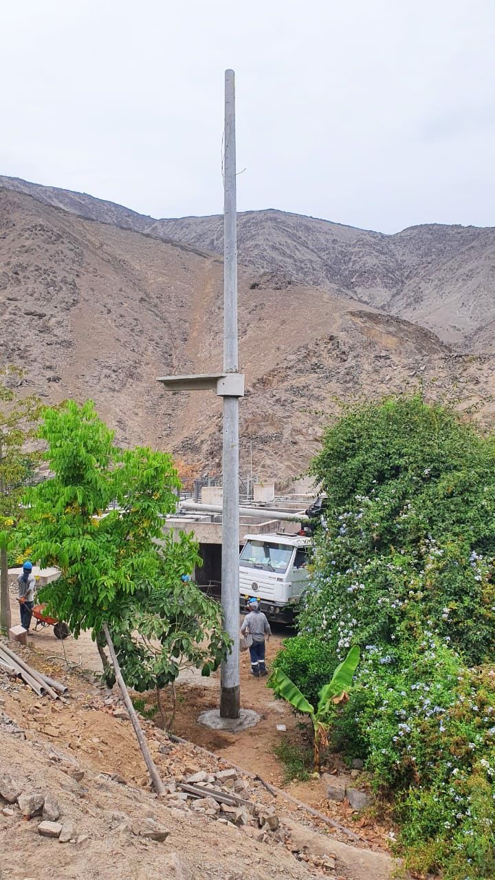 Un gran poste está situado en la cima de una colina en medio de un campo.