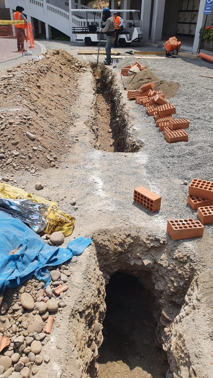 Un montón de ladrillos están tirados en el suelo junto a un agujero en el suelo.