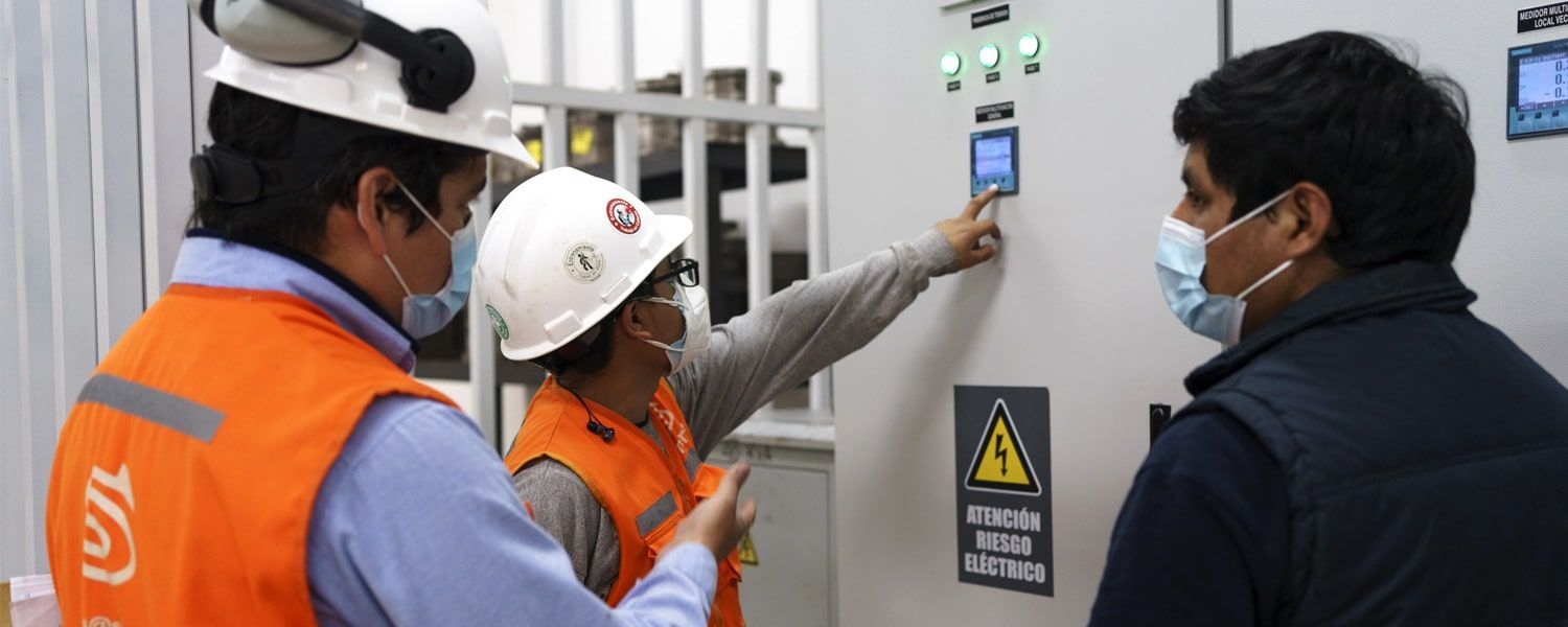 Un grupo de hombres que llevan cascos y máscaras están trabajando en una máquina.