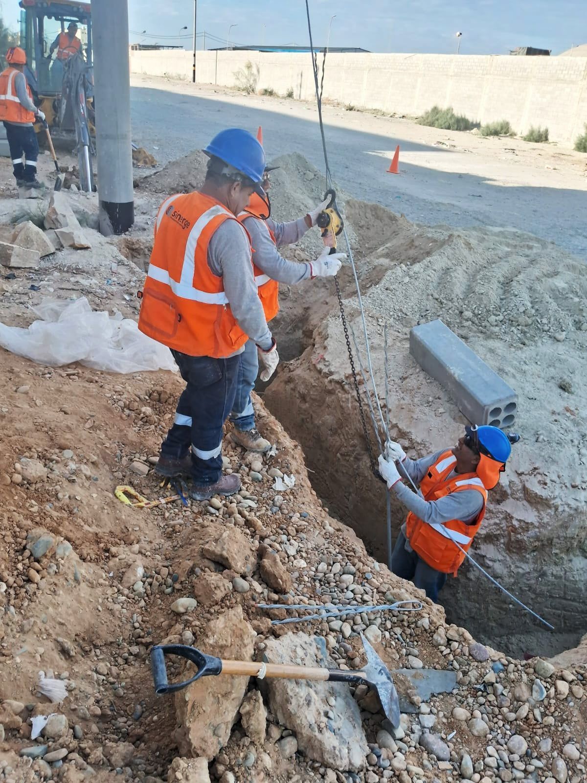 Un grupo de trabajadores de la construcción está cavando un hoyo en el suelo.