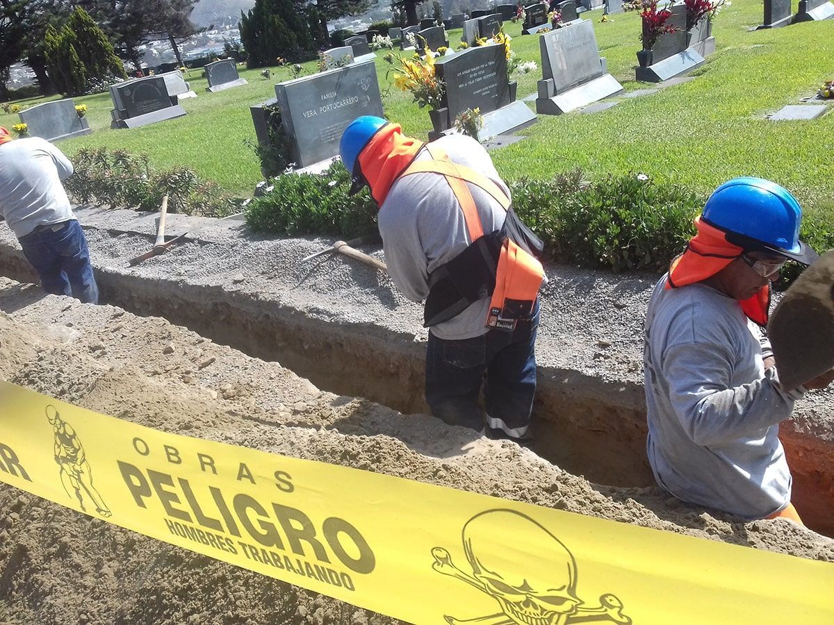 Un grupo de trabajadores de la construcción están cavando en un cementerio.