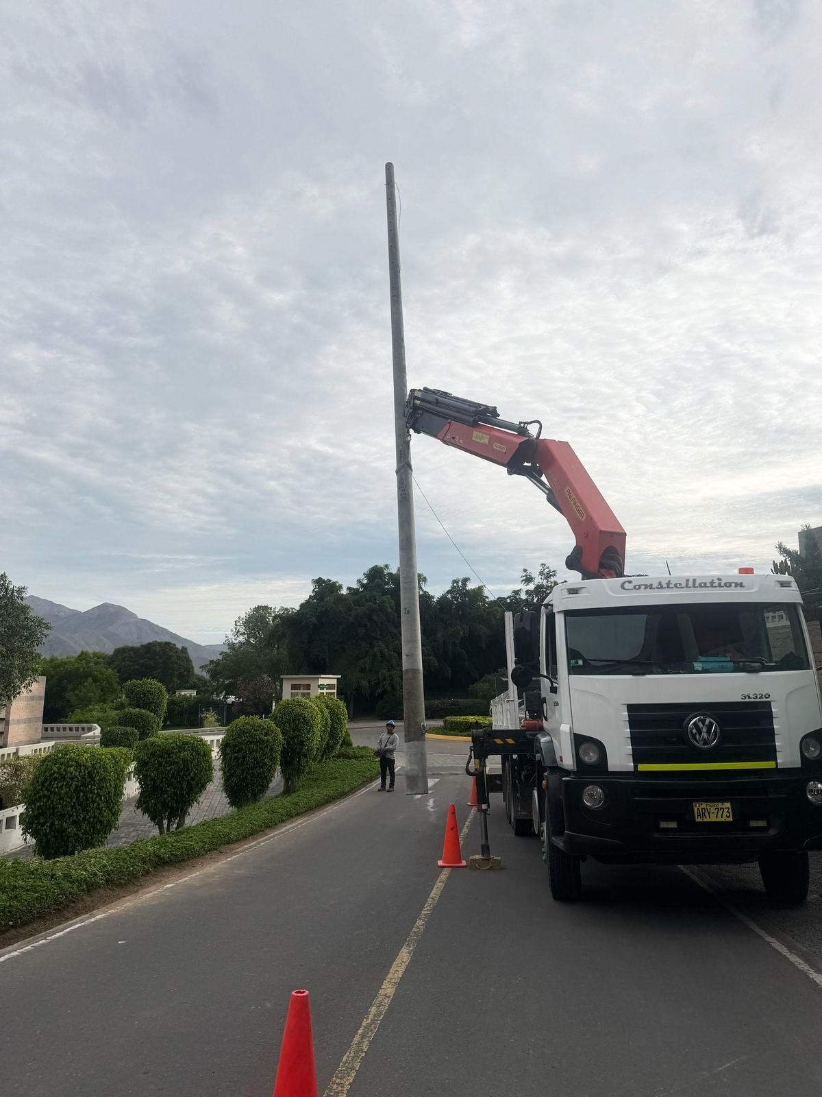 Un camión con una grúa acoplada está estacionado al costado de la carretera.