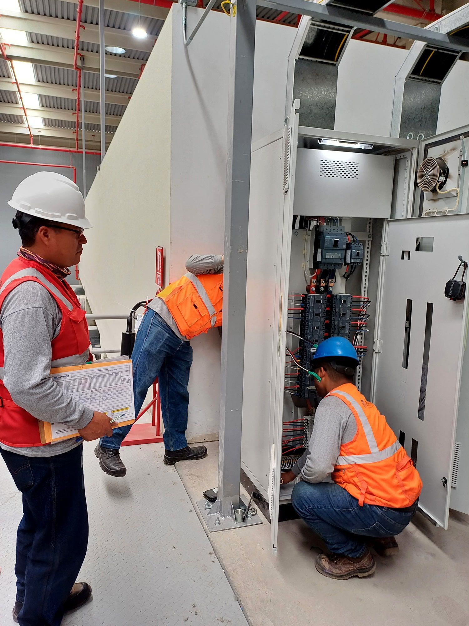 Un grupo de hombres está trabajando en una máquina en un almacén.