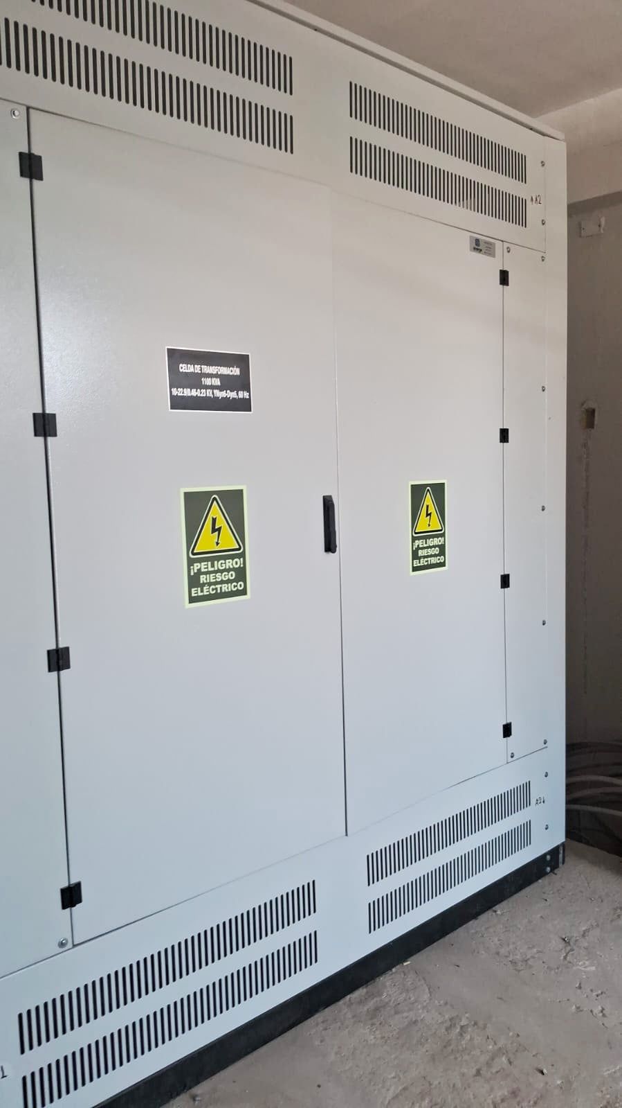 Un gran armario blanco con un cartel de advertencia amarillo sobre él.