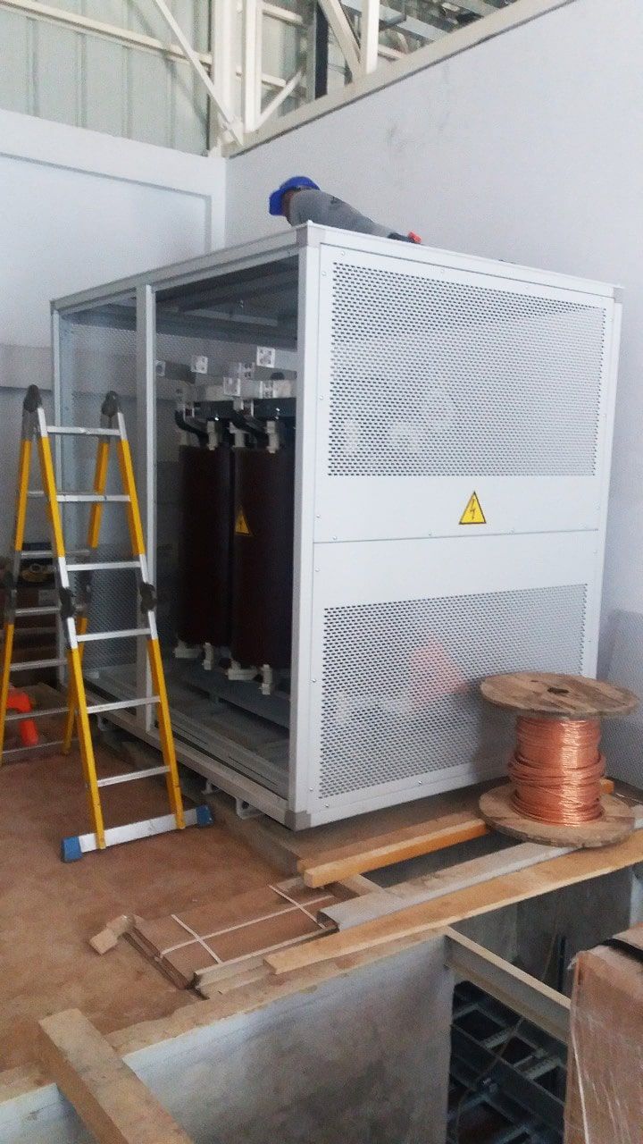 Una escalera está al lado de una gran caja eléctrica.