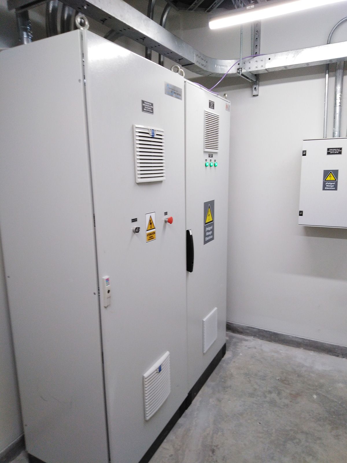 Una fila de armarios eléctricos blancos en una habitación.