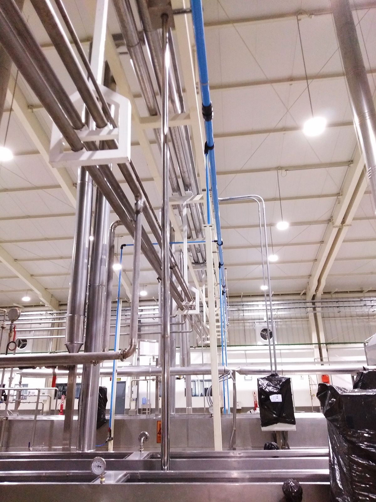 Un almacén con muchas tuberías colgando del techo.