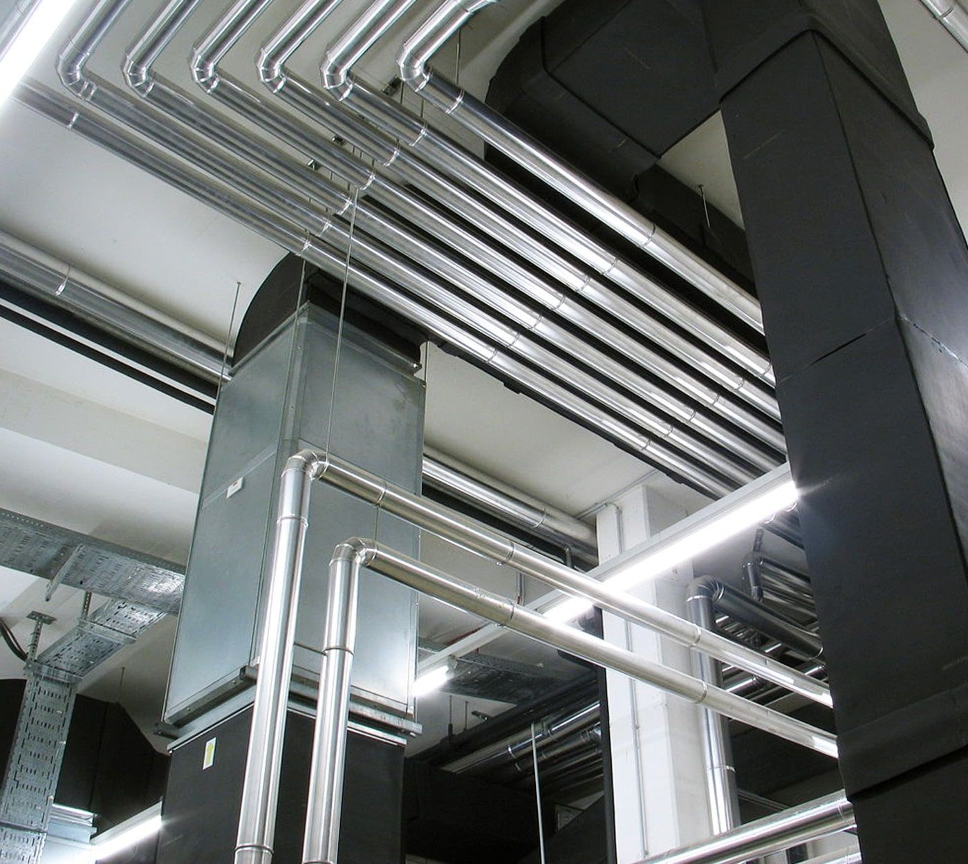 Un montón de tubos colgando del techo de un edificio.