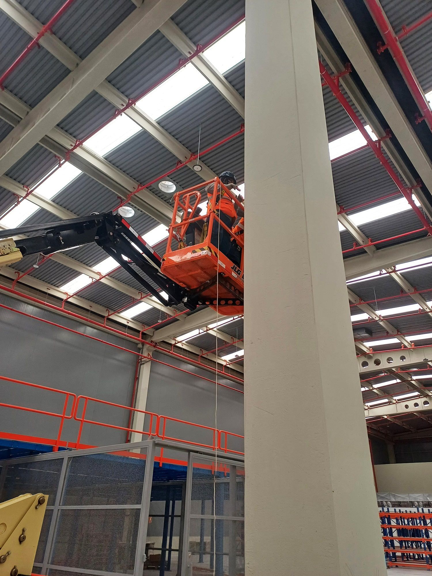 Una grúa está sentada encima de un pilar en un almacén.